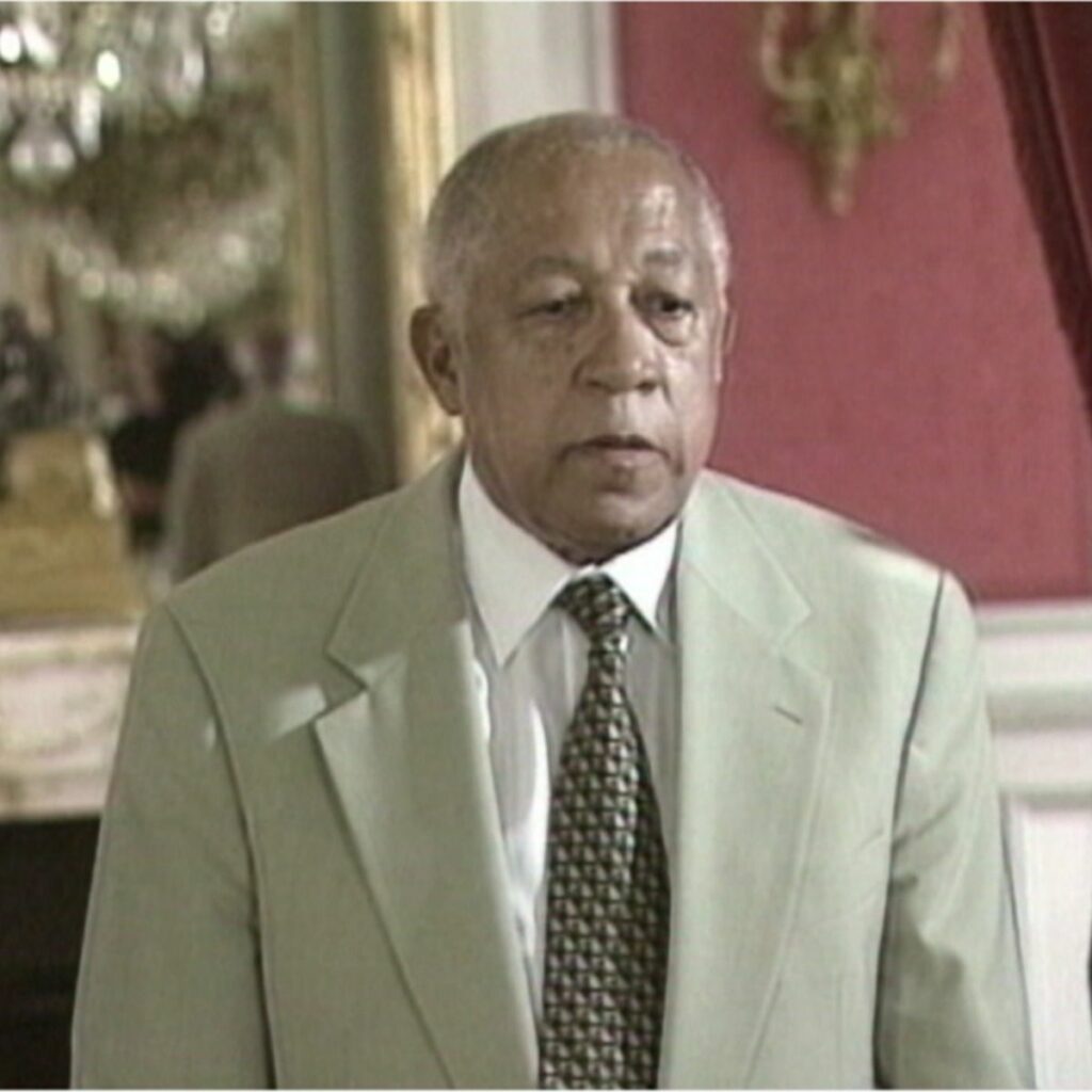 Portrait d'un homme politique comorien en costume lors d'une interview, lié aux événements des référendums et a l'indépendance des Comores. 
